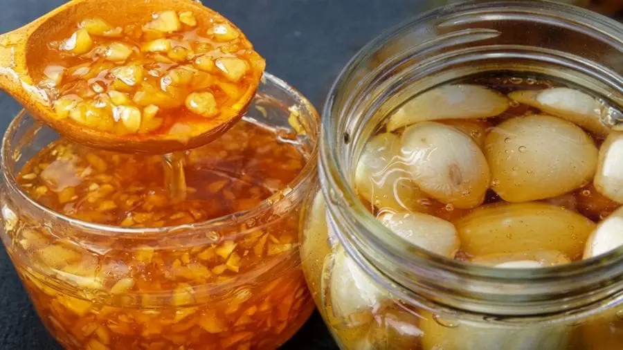 Conserva de alho com mel pode transformar suas receitas A conserva de alho com mel transforma dois ingredientes comuns em um condimento doce, picante e aromático