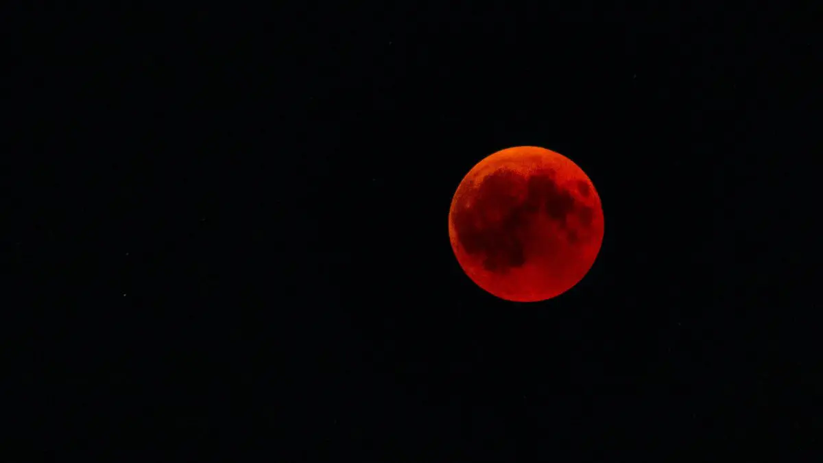 A Lua pode ficar vermelha porque a própria atmosfera da Terra filtra a luz do Sol e direciona principalmente tons avermelhados para dentro da sombra terrestre.